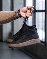 Чоловічі ботинки NERO BLACK чорні, боковий ракурс у руці