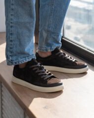 Темно-коричневі чоловічі кеди VORTEX BROWN на нозі біля вікна