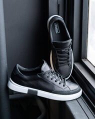 Чоловічі чорні кеди VORTEX BLACK біля вікна крупний план профілю